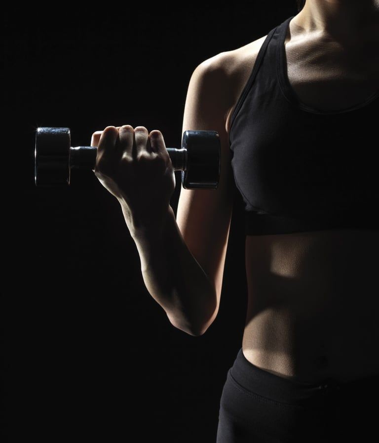 Athlete holding a dumbbell in a dark studio